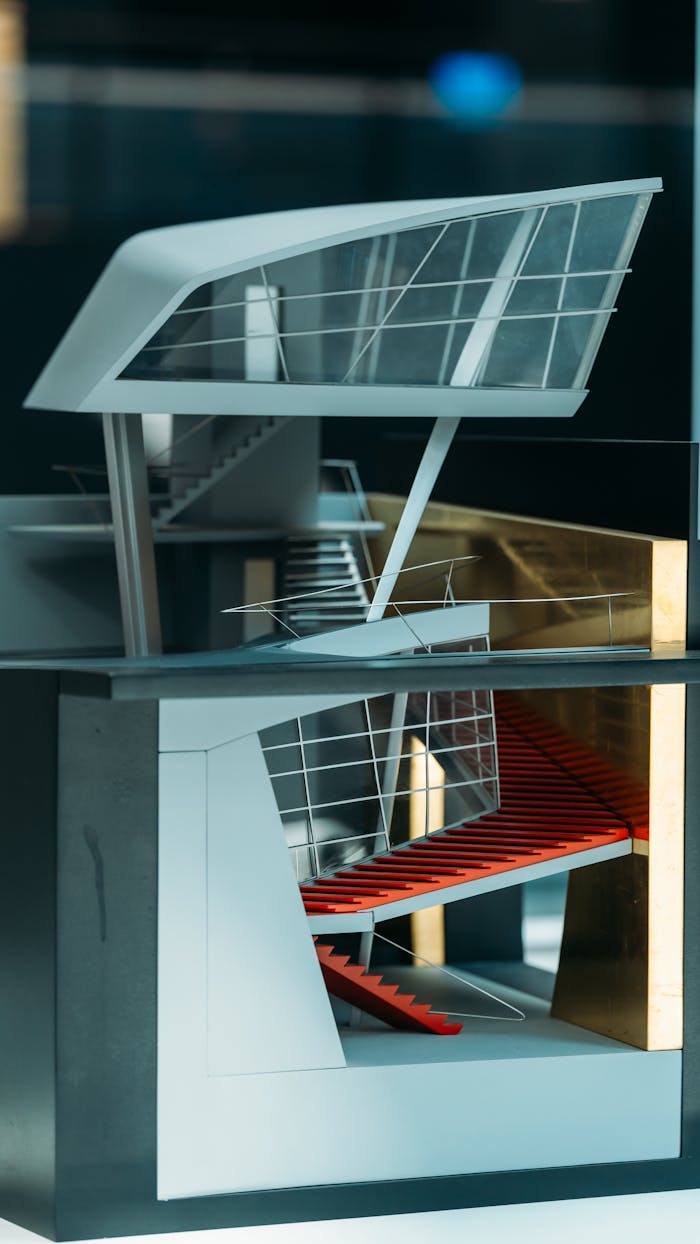 A detailed model of a modern building with a striking red interior staircase and large windows.